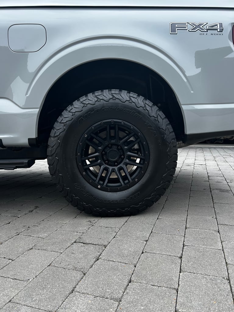 Silver FX4 pickup truck showing off-road tire and black wheel on brick surface