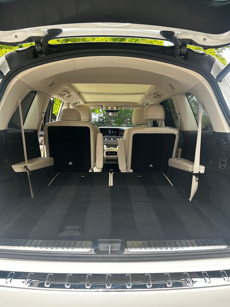 Interior view of an SUV cargo area with rear seats folded down, showing spacious storage compartment with beige upholstery